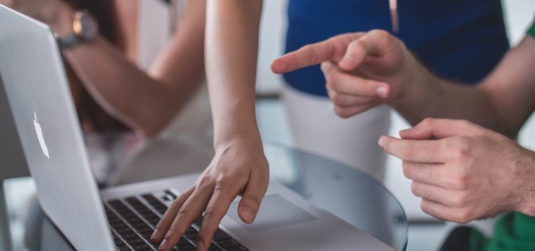 People pointing at computer
